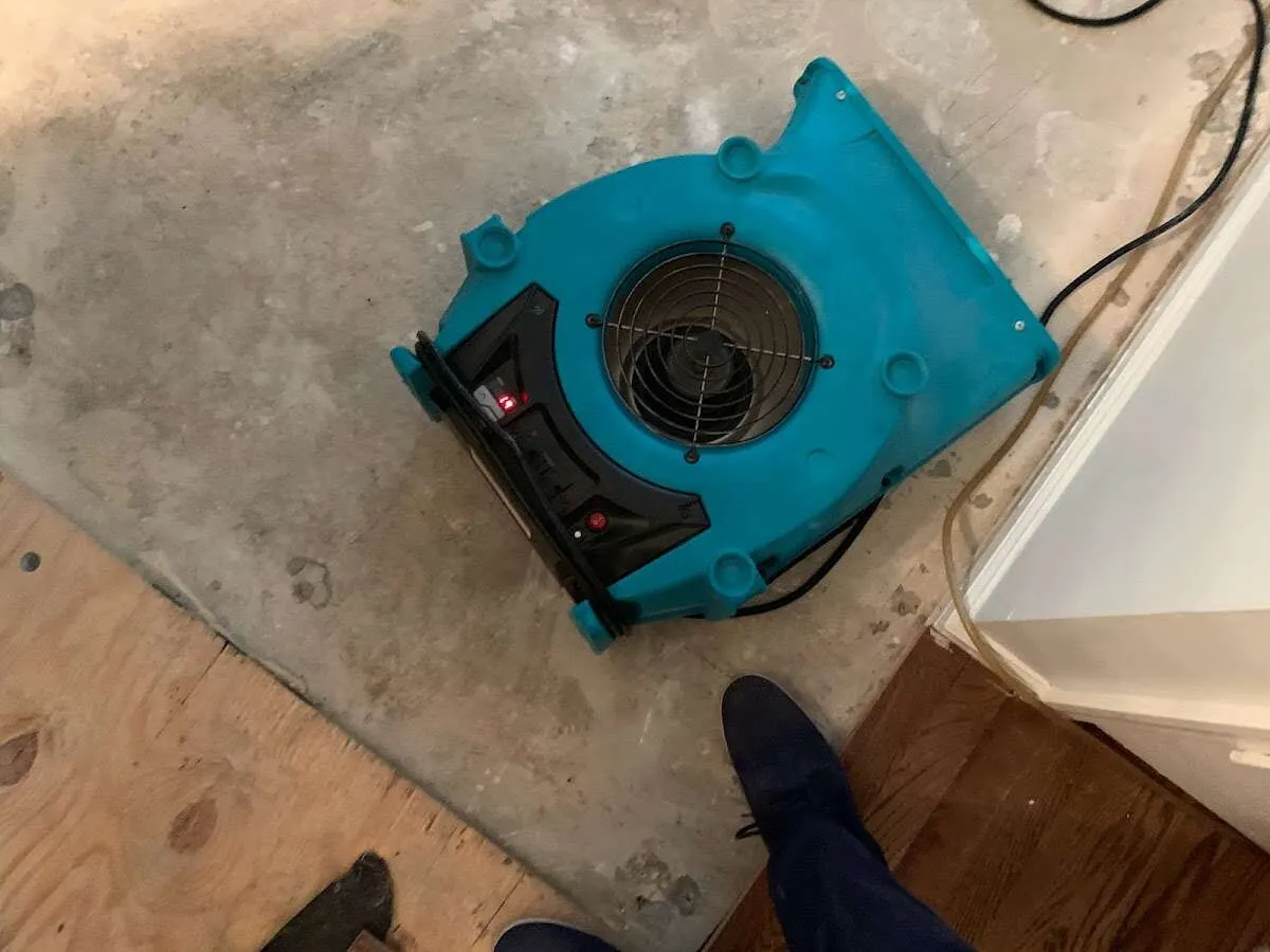 Air mover drying subfloor during Commercial Water Damage Restoration in Ranson corporation